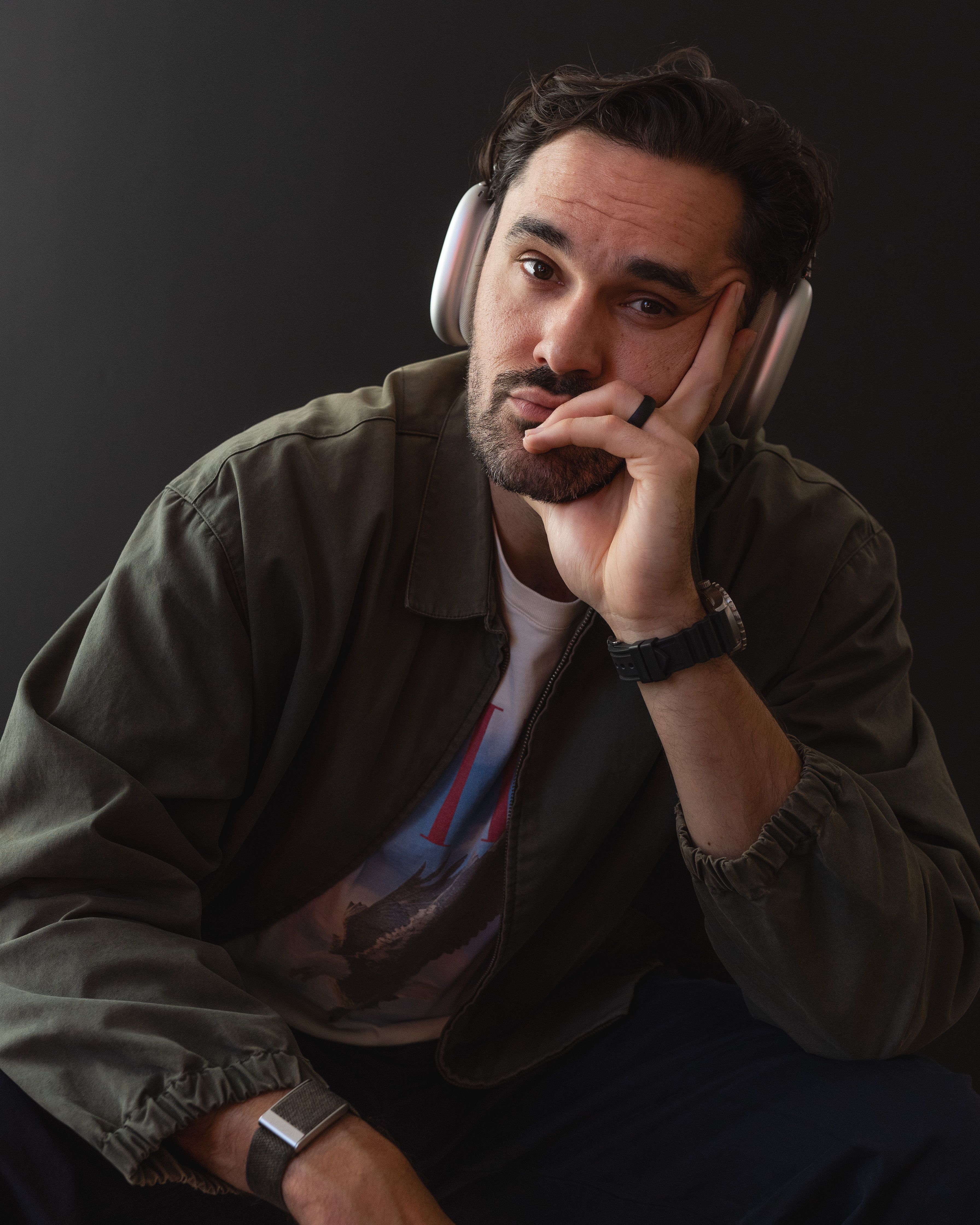 Rob Howe wearing headphones, chin resting on his hand